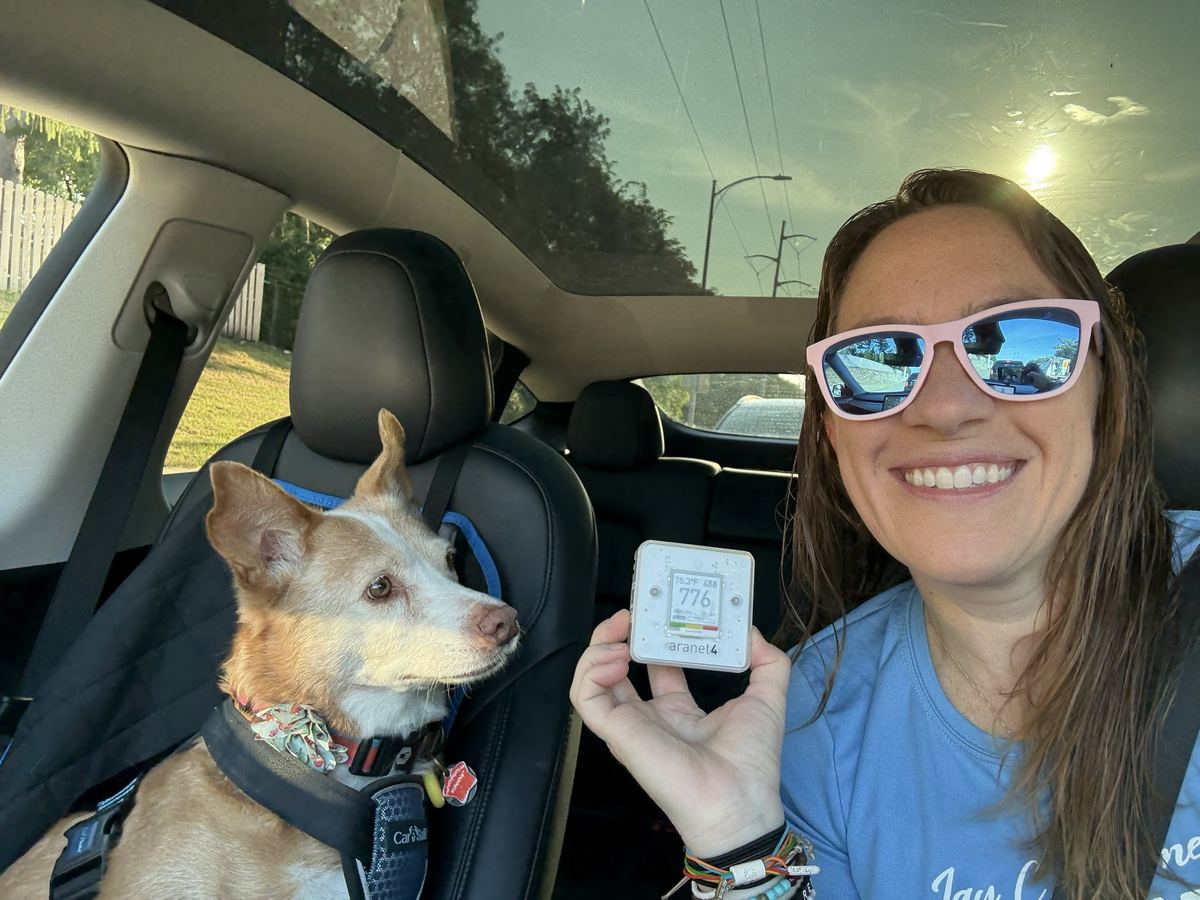 Selfie with her dog and an air quality monitor reading