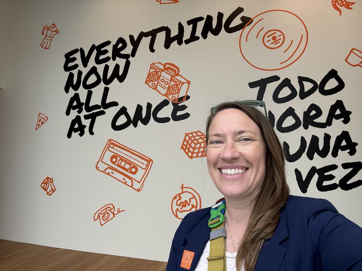 Selfie in front of a conference mural