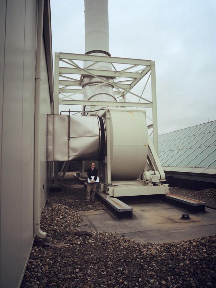 Standing on a roof next to a very large industrial fan